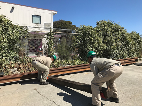 Trainees lift a rail tie 