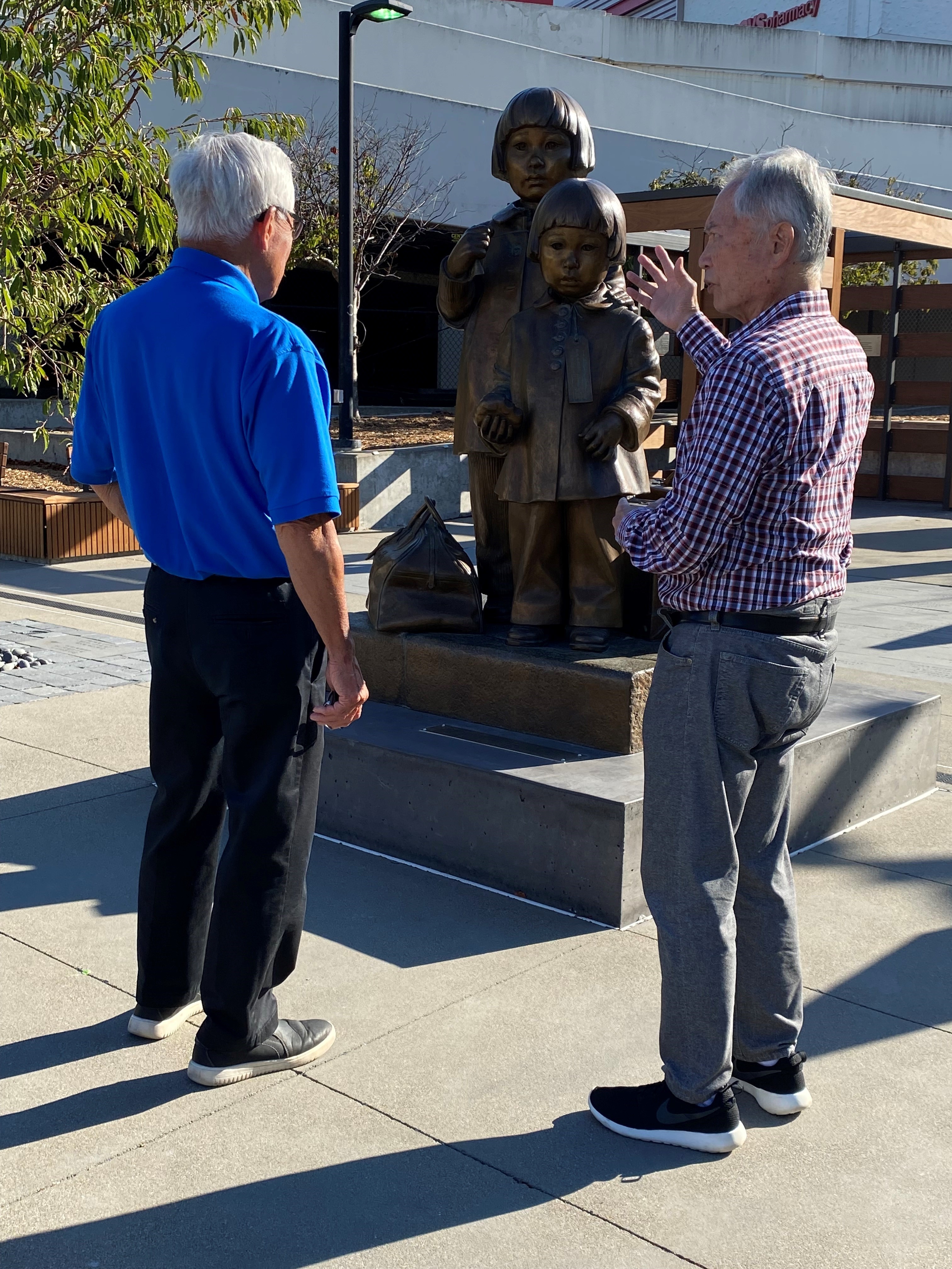 George Takei and Steve Okamoto looking at statue of Mochida sisters