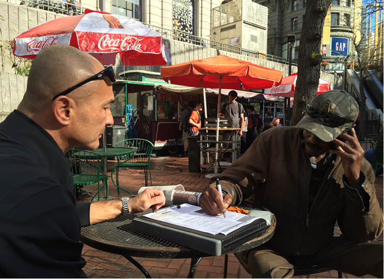 Dennis Johnson helps a man fill out paperwork