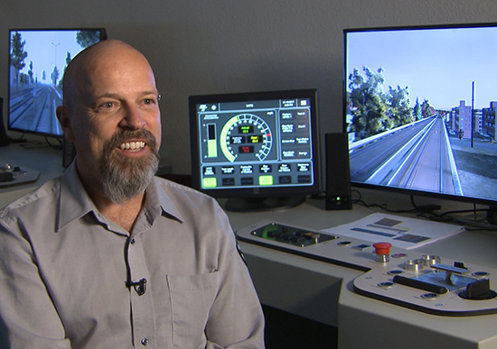 MIchael Patchen in front of desktop simulator stations