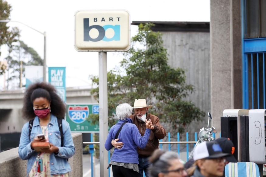 A couple dances below a BART sign on Oct. 7 at Glen Park Station