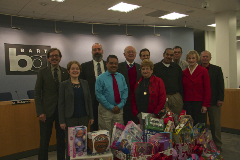 BART board of directors behind a pile of toys