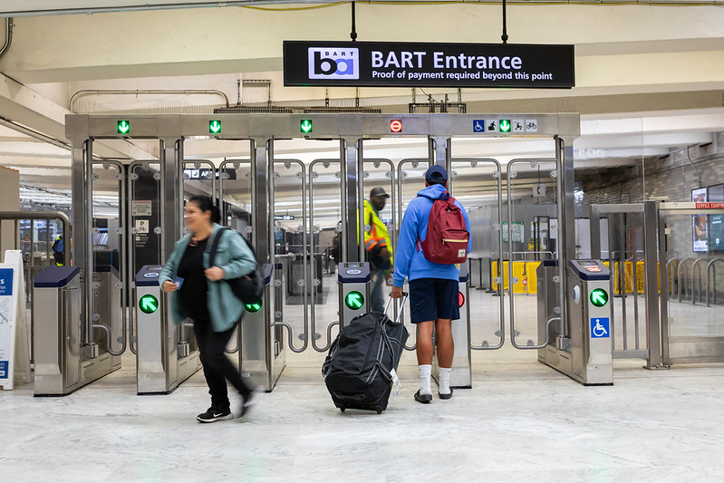 People enter and exit the new fare gates at Civic Center Station