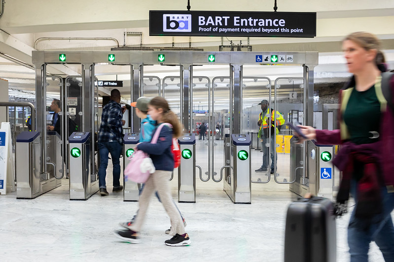 People enter and exit the new fare gates at Civic Center Station