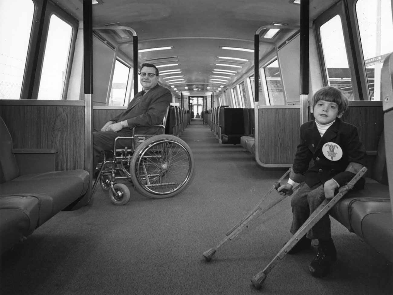 Harold pictured on a BART train on the left with Eric Staley, a young boy, seated on the right.