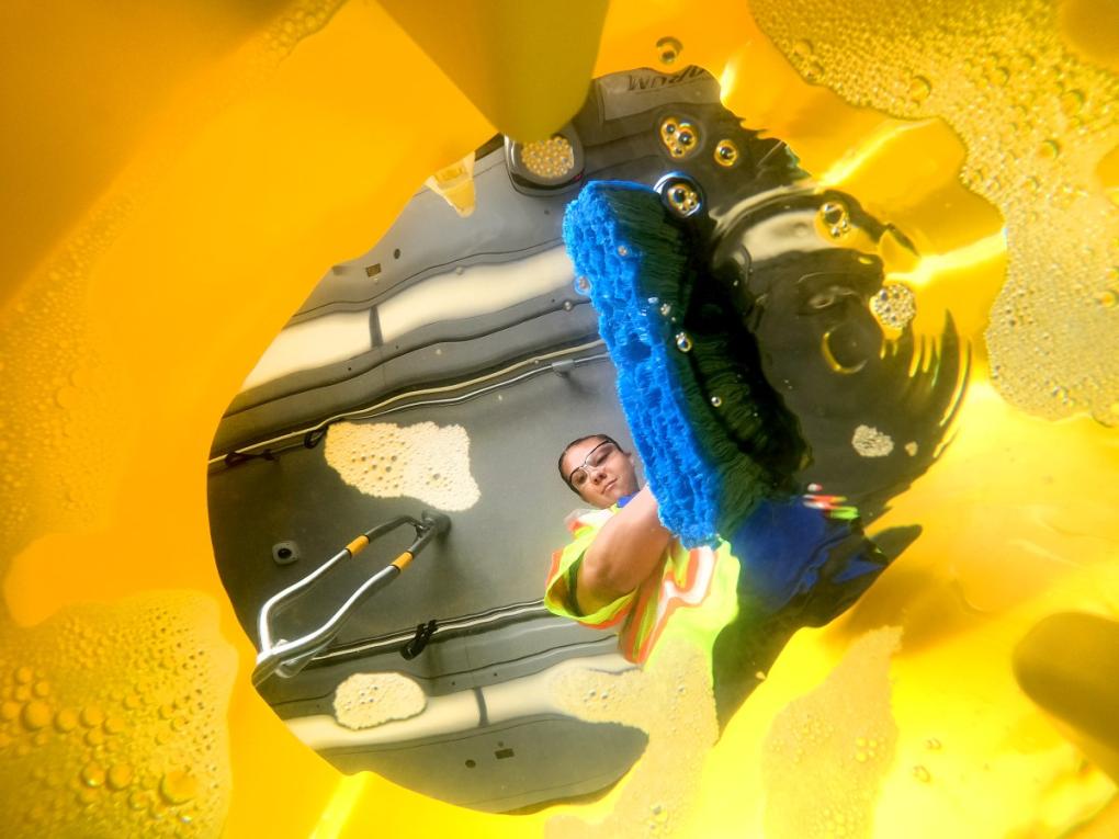 Train car cleaner Alyssa Barnes is pictured through a bucket of soapy water during a thorough clean.  