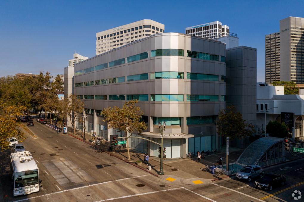 Silver four story office building with green glass. Future BART police headquarters