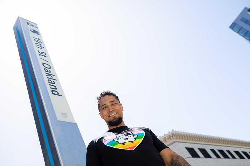 Joshua Munoz pictured smiling in front of the 19th St Oakland sign