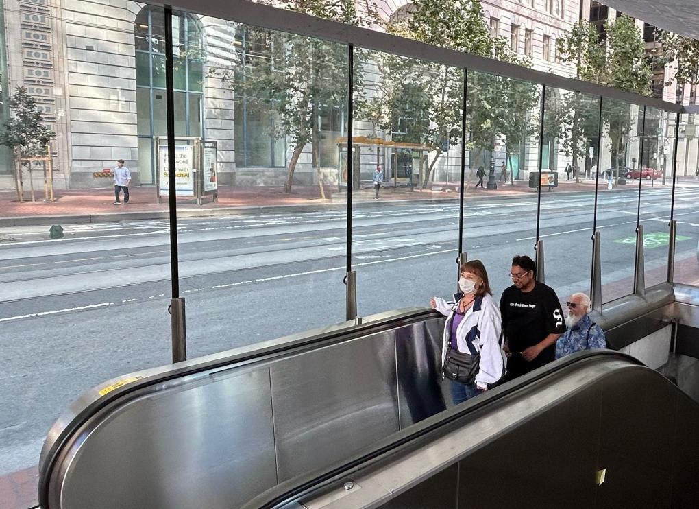 Riders enjoy the new escalator and canopy at Embarcadero Station