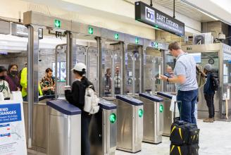 People enter and exit the new fare gates at Civic Center Station